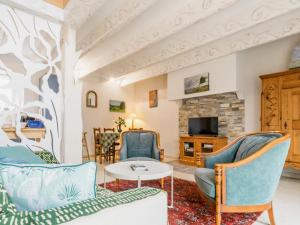a living room with blue chairs and a fireplace at Gîte breton proche plages et Guérande - terrasse, vélos inclus, animaux bienvenus - FR-1-306-1268 in Assérac +14 photos