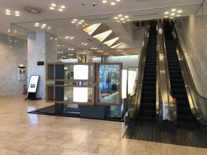 a lobby with an escalator in a building at Miyako City Osaka Tennoji in Osaka