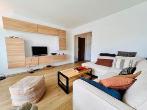 sala de estar con sofá blanco y TV en Appartement Quiberon, 2 pièces, 4 personnes - FR-1-478-271, en Quiberon