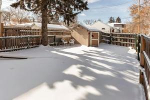 un patio cubierto de nieve con una valla y un árbol en Cozy Furnished Room in Edmonton - Close to U of A en Edmonton