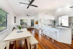 a kitchen and living room with a table and chairs at Alex Heads Beach Haven in Alexandra Headland