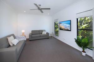 a living room with a couch and a window at Alex Heads Beach Haven in Alexandra Headland
