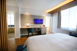 a hotel room with a bed and a desk with a television at Holiday Inn Express Chengdu North Railway Station, an IHG Hotel in Chengdu