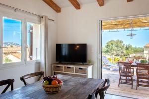 カルヴィにあるBel Appartement "Hortensia" avec grande terrasse 4 à 6 personnesのテーブルとテレビのあるダイニングルーム