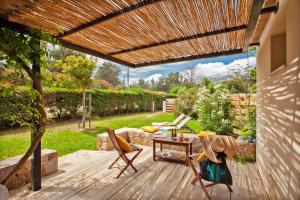 un patio avec une terrasse en bois et une pergola en bois dans l'établissement Very warm villa "Acacia" with beautiful garden - 46 people, à Calvi