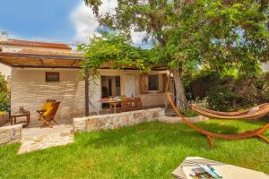 a hammock in the yard of a house at Villa "Acacia" très chaleureuse avec beau jardin - 4 à 6 personnes in Calvi