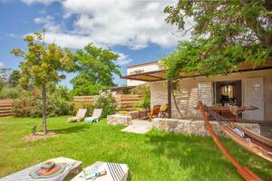 une arrière-cour avec un hamac et une maison dans l'établissement Very warm villa "Acacia" with beautiful garden - 46 people, à Calvi