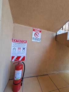 una habitación con una boca de incendios y carteles en la pared en Hotel Real Alaska, en Liberia