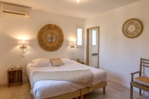 1 dormitorio con cama y espejo en la pared en Villa Albizzia with terrace and garden 68 people en Calvi