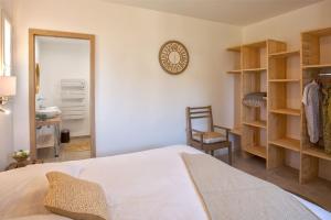 a bedroom with a bed and a clock on the wall at Villa Albizzia with terrace and garden 68 people in Calvi