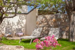 卡爾維的住宿－Villa Albizzia with terrace and garden 6 8 people，庭院设有两把椅子,还种植了鲜花