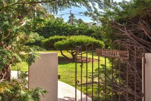 een poort naar een tuin met een bord erop bij Villa Albizzia with terrace and garden 6 8 people in Calvi
