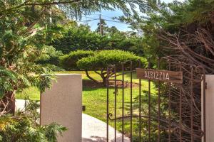 un cancello per un giardino con un cartello sopra di Villa "Albizzia" avec terrasse et jardin 6 à 8 personnes a Calvi