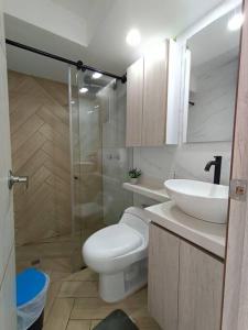 y baño con aseo, lavabo y ducha. en Apartamento - Cardio Infantil CTIC, en Bogotá