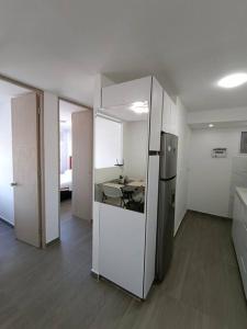 an empty room with a kitchen with a refrigerator at Apartamento - Cardio Infantil CTIC in Bogotá