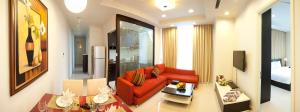 sala de estar con sofá rojo y cama en Mayfair Suites, en Ho Chi Minh