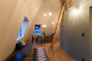 Habitación con escalera, mesa y sillas en 野沢温泉ロッヂ, en Nozawa Onsen