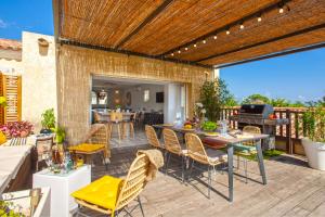 un patio avec une table, des chaises et un grill dans l'établissement Apartment "Jasmin" 3 bedrooms with large terrace 68 people, à Calvi