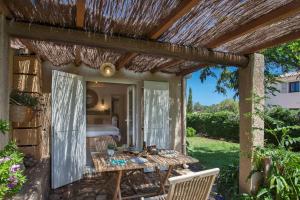 an outdoor patio with a table and chairs at Small quiet house Dracena with its pretty garden - 2 people in Calvi