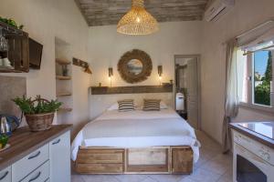 a bedroom with a bed and a chandelier at Small quiet house Dracena with its pretty garden - 2 people in Calvi