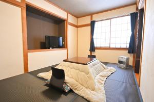a room with a bed and a tv in it at Hütte Jil Shirakabako in Chino