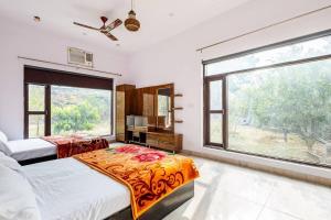 a bedroom with two beds and a large window at Aravali hills resort in Gurgaon