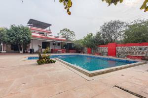 a swimming pool in front of a building at Aravali hills resort in Gurgaon