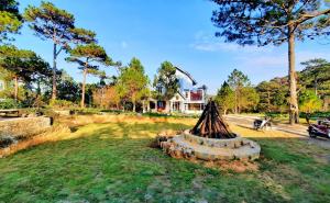 a stump in the grass in front of a house at Kim Ngan Hills Resort Da Lat. in Da Thien