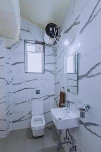 Silver Galaxy Resort في بانتشجانى: حمام أبيض مع حوض ومرحاض