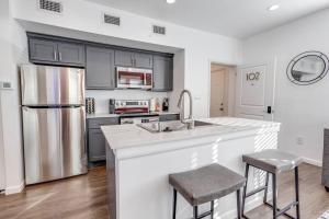 una cocina con fregadero y refrigerador en Velouté Valor - 1BD Near Med Center & Museum District, en Houston