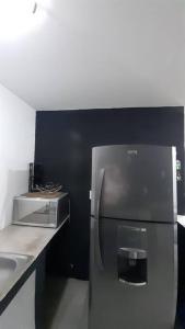 a stainless steel refrigerator in a kitchen next to a counter at Hospedaje Feria de San marcos 2024 Para 8 Personas in Aguascalientes