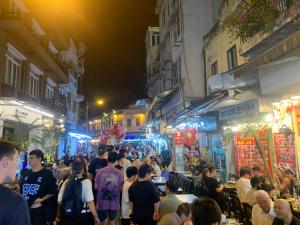 una multitud de personas caminando por una calle por la noche en Huong’s Family homestay en Hanói