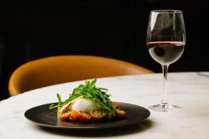une assiette de nourriture et un verre de vin sur une table dans l'établissement Hilton Brisbane, à Brisbane