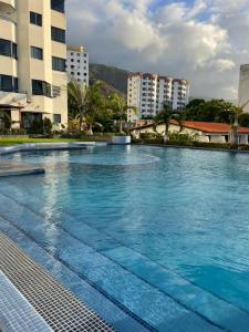 a large swimming pool with blue water in a city at Contry Mar Caraballeda in Caraballeda