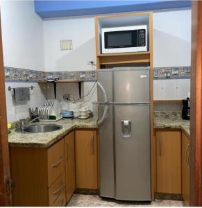 a kitchen with a stainless steel refrigerator and a microwave at Contry Mar Caraballeda in Caraballeda