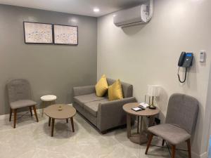 a living room with a couch and two chairs and a phone at Hayat Sky Towers Service Apartment in Cebu City