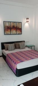 a bedroom with a large bed with a colorful blanket at THE CLASSIC-Hostel-apartment-Standard Room in Weligama