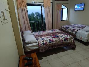 a bedroom with two beds and a balcony at Hotel Brisas del Pacifico #2 in Puerto López
