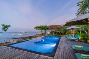 a swimming pool with a view of the ocean at D'Muncuk Huts Lembongan in Nusa Lembongan