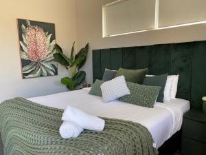 a bedroom with a large bed with green and white pillows at Maand Up Fremantle in Fremantle