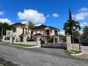 een huis met een smeedijzeren poort op een straat bij Mandeville luxury in Mandeville