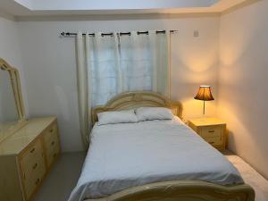 een slaapkamer met een bed, een dressoir en een raam bij Mandeville luxury in Mandeville