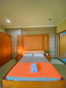 una camera da letto con un letto con due infradito di Rumah palala a Kampungdurian