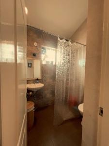 uma casa de banho com uma cortina de chuveiro e um lavatório em The Source em Goa