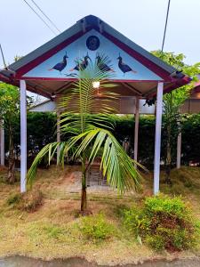 a gazebo with birds on it with a palm tree at Pauwa Garden Resort in Nagarkot