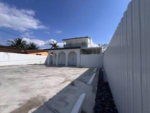 un edificio blanco con una valla al lado de un edificio en Modern apartment near Wynwood! en Miami