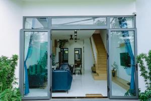 a glass door of a house with a living room at Ninh Hoa Garden in Buon Ma Thuot