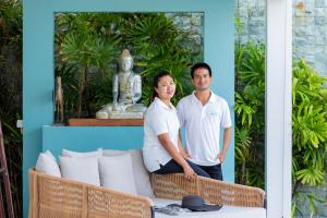 een man en een vrouw die voor een tafel staan bij Villa Playa Samui in Choeng Mon Beach