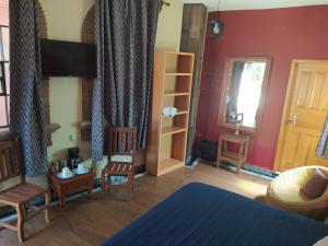 a bedroom with a bed and chairs and a window at Hotel Villas San Miguel in Pátzcuaro