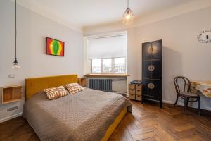 a bedroom with a bed and a table and a window at Baltic Design Apartments with free Parking in Riga